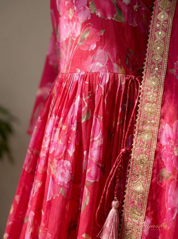 Detail Close-Up Close-up shot of intricate embellishments and embroidery on vibrant Rani pink fabric.
